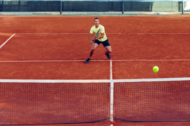游戏在粘土网球场上打网球的年轻帅哥比赛运动服运动
