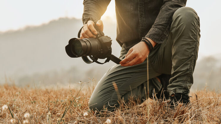 天气拍摄风景 特写年轻的亚洲男摄影师在拿着相机风景自然夹克