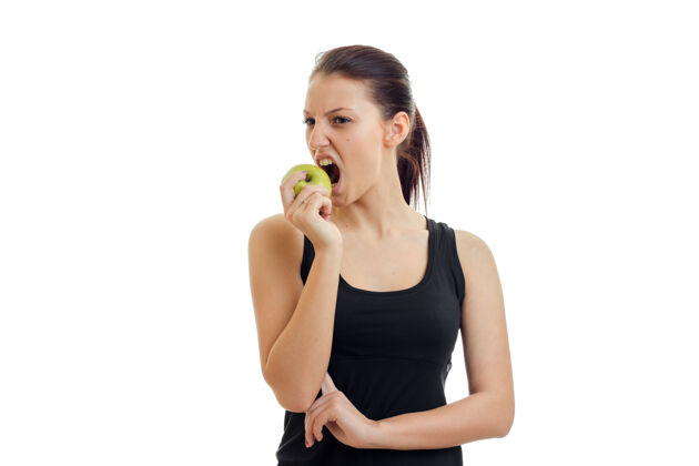 腰围一个穿着黑色t恤的年轻女子被咬的苹果孤立在白墙上健康礼品健康