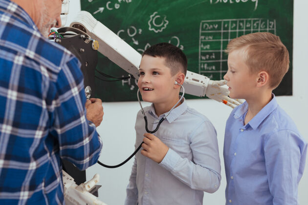 童年感觉一下可爱可爱的男孩一边戴着听诊器一边听电子机械儿童机械机械