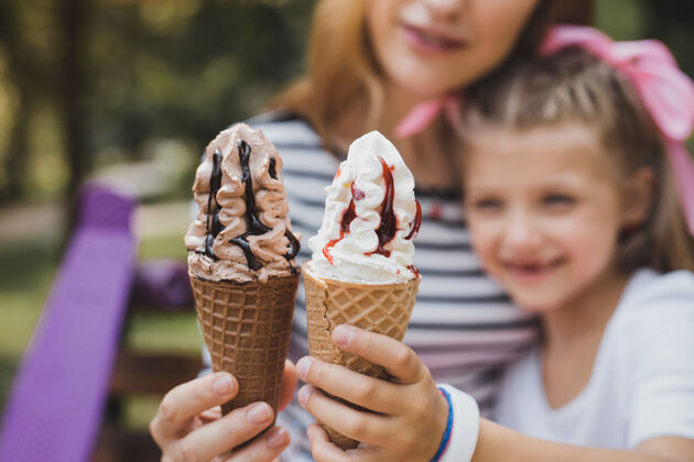 女儿巧克力和香草妈妈和女儿在吃美味可口的巧克力和香草冰淇淋休息情绪香草