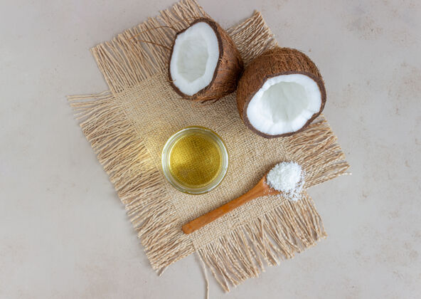 芳香把椰子油放在罐子里 新鲜椰子放在米色的表面天然化妆品健康营养瓶子