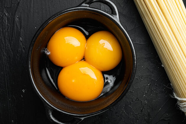 蛋黄亮黄色的蛋黄套 放在黑色的石桌上 俯视平铺食品配料有机