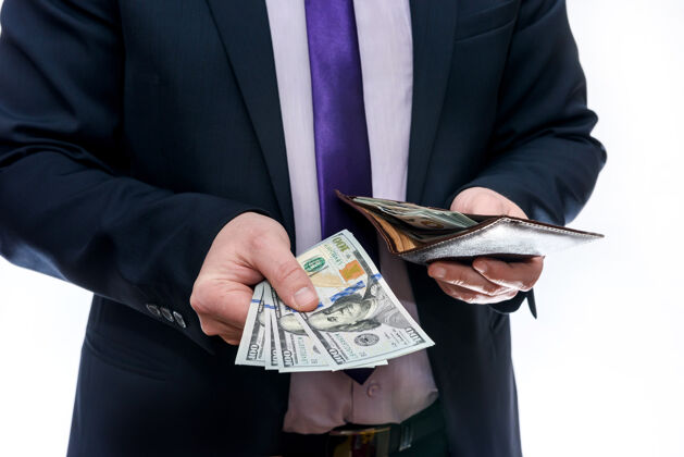 繁荣一个拿着白色背景的美元钞票的男人在展示钱包显示财富经济