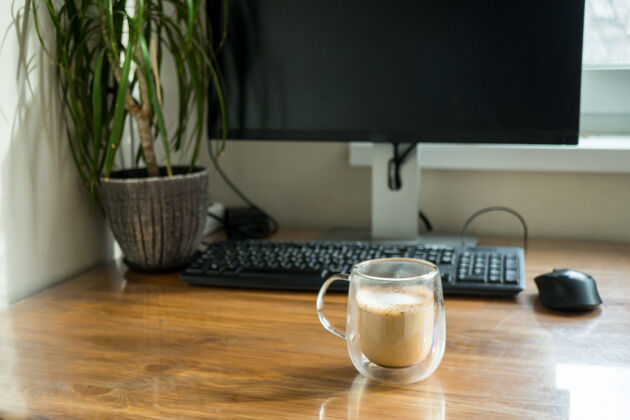 咖啡家庭办公室内部配备笔记本电脑和一杯咖啡工作场所笔记本电脑室内