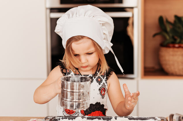食物戴着厨师帽的小女孩在厨房里玩面粉孩子女孩童年