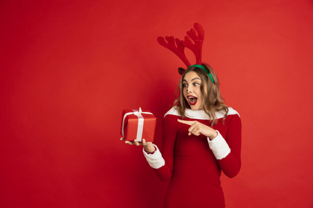 庆祝指着礼物圣诞节的概念 2021年的新年 冬天的心情 假期…美丽的高加索女人长发像圣诞老人的驯鹿抓礼物盒传统积极节日