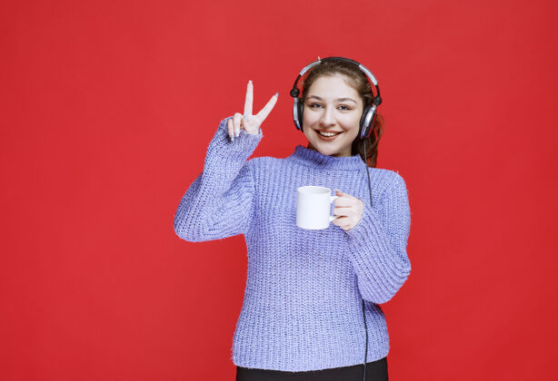 女性戴着耳机享受咖啡味道的女孩人类年轻音乐