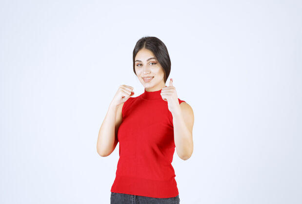 模特穿红衬衫的女孩展示着快乐的手势满意积极女性
