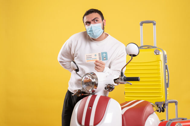 面具顶视图的旅游概念与好奇的年轻人在医疗面具站在摩托车附近运动人球员