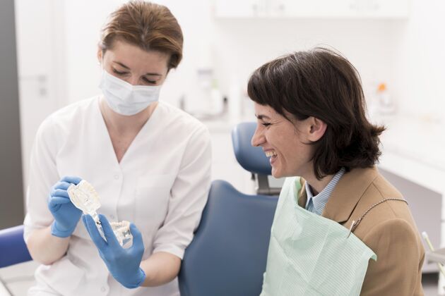 从业者女患者正和正畸医生一起看牙模职业工作医疗