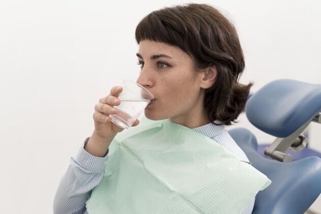 饮用水女病人在牙科手术前在牙科诊所喝水工作医疗雇员