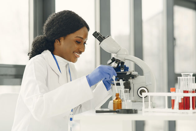 职业医学博士 一个拿着显微镜工作的女孩年轻的女科学家在做疫苗研究微生物学工作医学