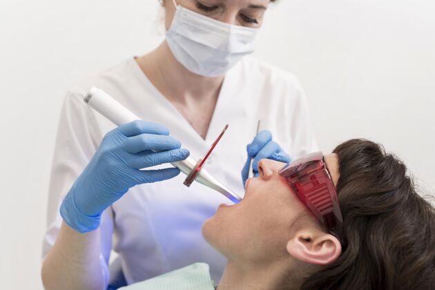 雇员在牙医那里做手术的女病人乳胶手套就业牙医