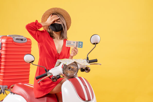 车辆疲惫的年轻女士骑着轻便摩托车 手里拿着一个红色的手提箱 手放在头上车票摩托车疲惫的小姐
