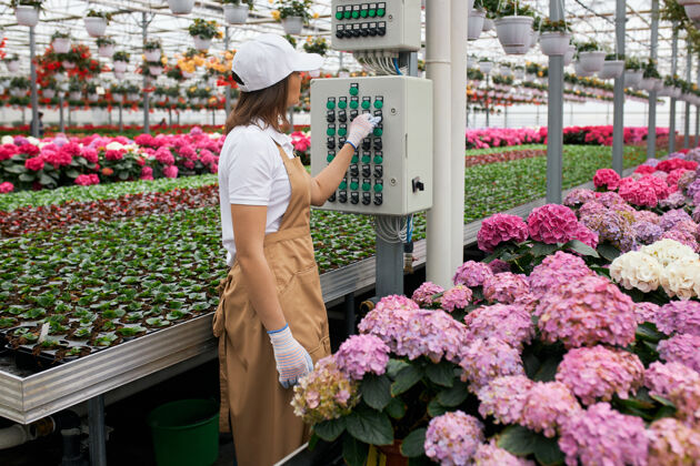 手套女园丁用现代设备浇花机器种植园农业