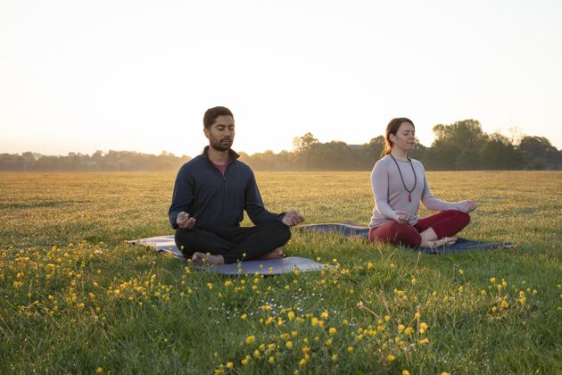 瑜伽男人和女人一起在户外做瑜伽锻炼冥想外面