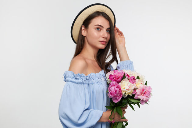 完美快乐的女人 深色长发 戴着帽子 穿着蓝色漂亮的裙子 手里拿着一束花 抚摸着头发装装人女士