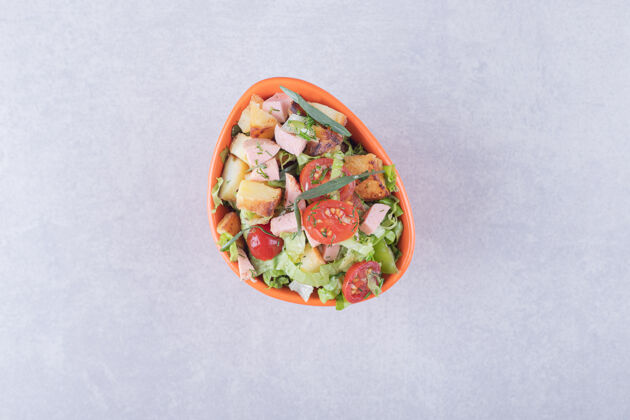 块一碗新鲜沙拉 香肠放在大理石背景上沙拉生菜肉