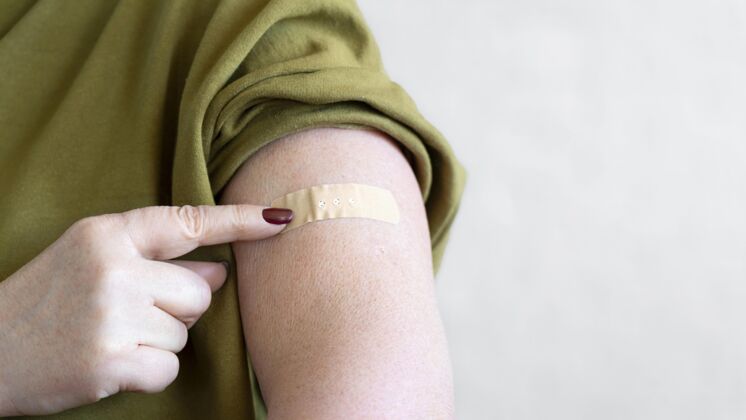 注射接种疫苗后手臂缠绷带的女人安全水平治疗