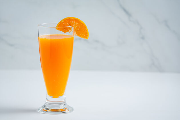 木头新鲜的橙汁在玻璃大理石背景上玻璃杯切割美味