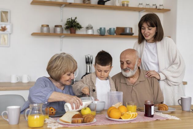 老人中景快乐家庭在餐桌上退休女人孩子