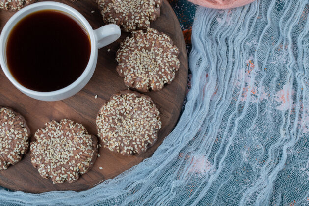 香草可可芝麻饼干放在乡村木板上 配上一杯茶顶视图奶油喜悦
