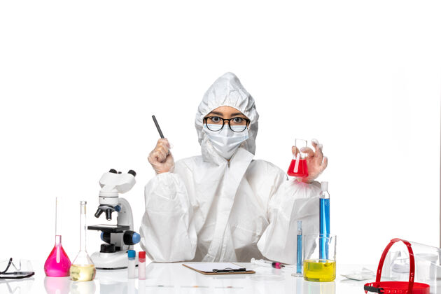 化学前视图年轻的女化学家穿着特殊的防护服拿着白色背景上的红色溶液-化学病毒实验室医生专业实验室