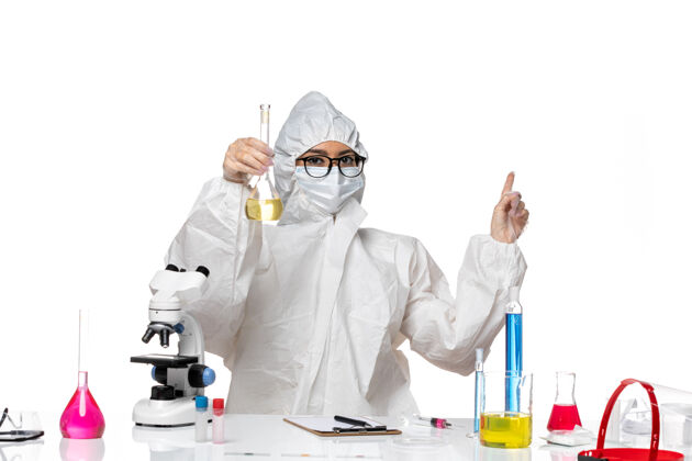 特殊正面图身穿特殊防护服的年轻女化学家拿着装有淡白色背景溶液的烧瓶实验室病毒化学医生药品溶液