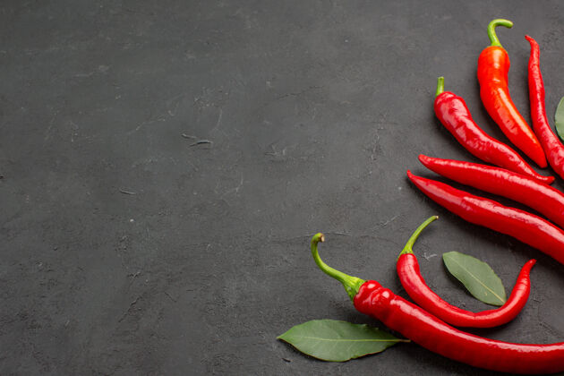 蔬菜在黑桌子的右边 可以看到红辣椒和荷叶配料烹饪辣椒