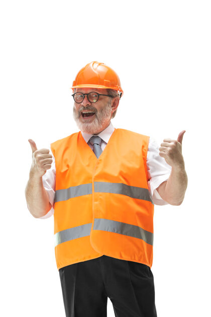 Ok穿着建筑背心和橙色头盔的快乐的建设者在工作室微笑建筑工人男性