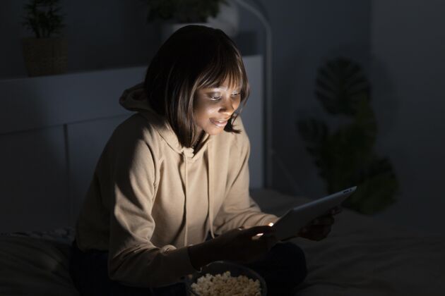 电视笑眯眯的非洲裔美国女人在家看netflix系列订阅用户