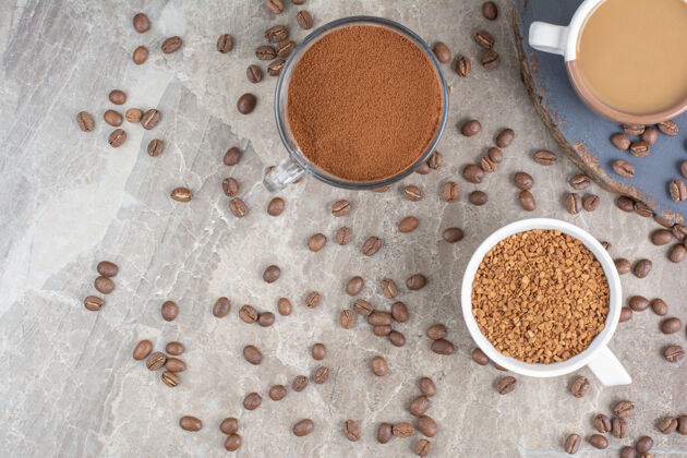 一杯咖啡 咖啡豆和磨碎的咖啡放在大理石表面磨碎的豆子浓缩咖啡