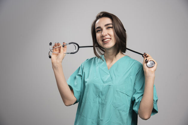 个人穿着制服的年轻医生用听诊器摆姿势高质量的照片听诊器女性工作