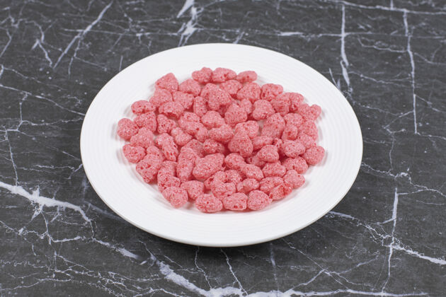 谷类食品白色盘子上有粉红色的麦片球松脆玉米