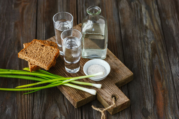 酒精伏特加和传统小吃在木墙上食物桌子蔬菜
