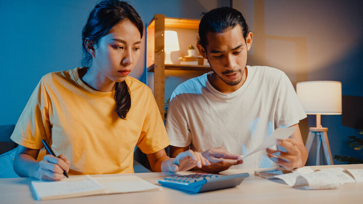 沮丧强调亚洲夫妇男女使用计算器计算家庭预算关系夜晚压力