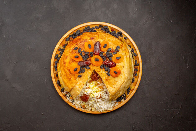 陶瓷器皿在黑暗的表面上俯瞰着美味的沙赫普洛夫葡萄干和杏干陶器晚餐饭