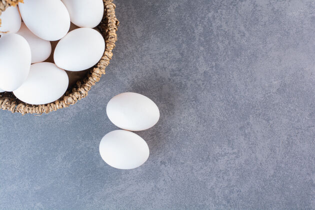营养柳条篮子装满有机鸡蛋放在石桌上家禽有机新鲜