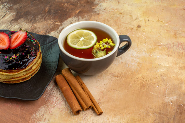 碗前视图美味的甜煎饼和一杯茶放在一张桌子上蛋糕甜甜点牛奶美食新鲜美味