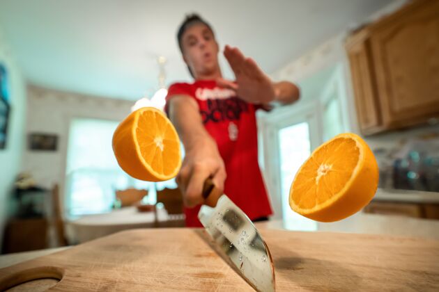 水果特写镜头的两个橙色的一半在空气中削减了一个男性的背景食物新鲜部分