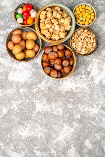 食品榛子和花生的顶视图 白色表面有糖果饮食健康小吃
