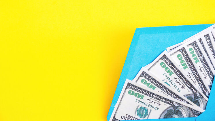 背景黄色背景上有钱的蓝色信封硬币财富储蓄