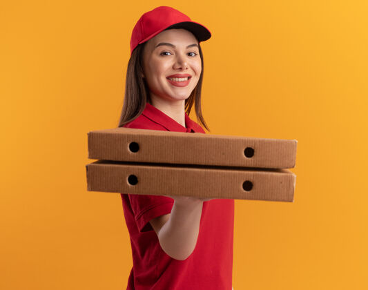 送货身着制服的微笑漂亮的送货员站在一旁 手里拿着橘黄色的比萨饼盒橘子盒子女人