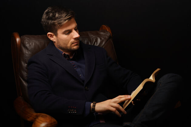 年轻特写镜头：一个穿着优雅西装的成熟男人坐在皮沙发上看书沙发衬衫帅气