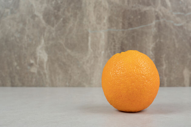 自然新鲜的整个橘子放在灰色的桌子上食物多汁美味