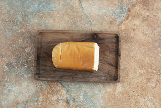 大理石大理石桌上放着一块有奶酪的木板奶酪切片切