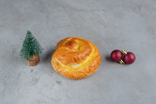 圣诞节小树人 甜面包和装饰球安排在大理石桌上精致美味美味