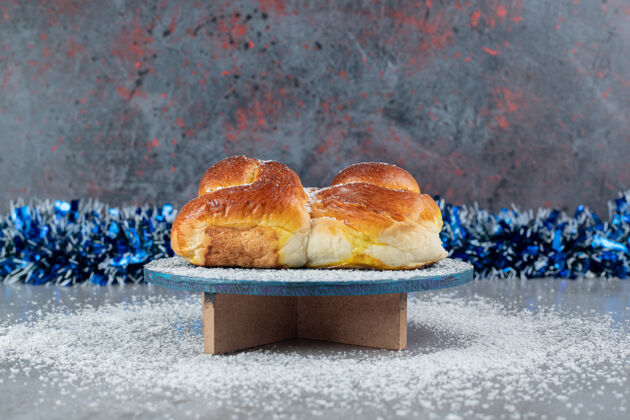 甜点大理石桌上的架子上挂着一个甜面包后面的一排金属丝美味糕点美味