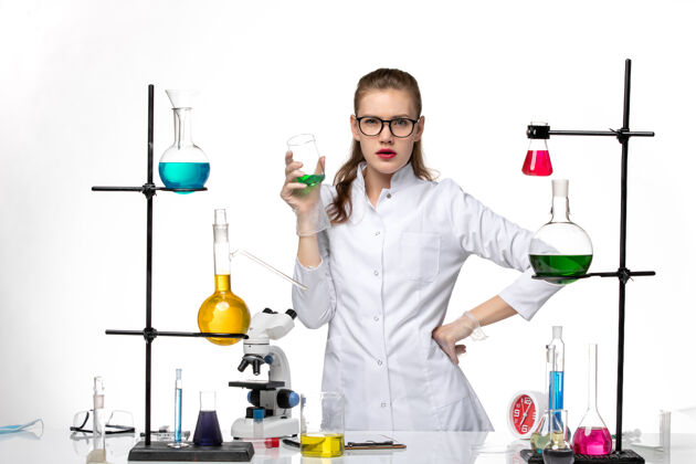 人前视图身着医疗服的女化学家在工作过程中用浅白背景上的溶液化学大流行的病毒医学专业浅白